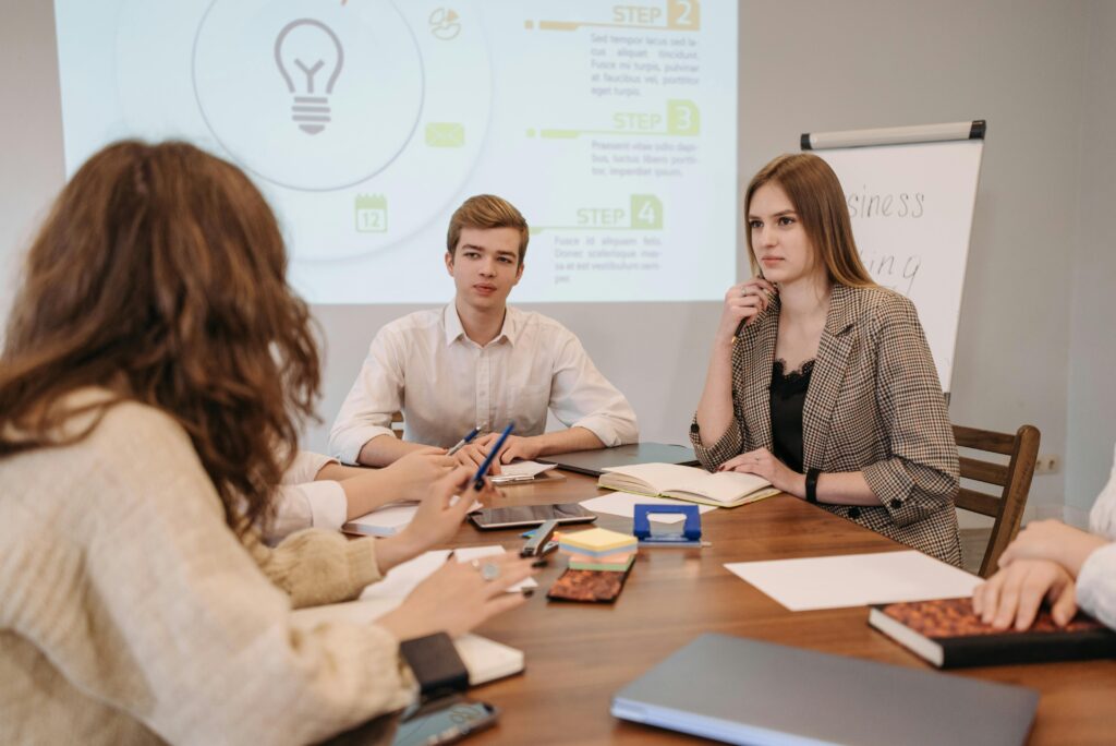 A group of young professionals in a modern office setting discussing ideas during a meeting.